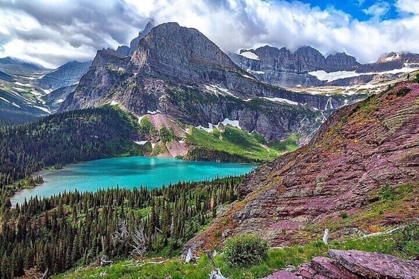 A mountain lake surrounded by forest and rocky terrain. 1