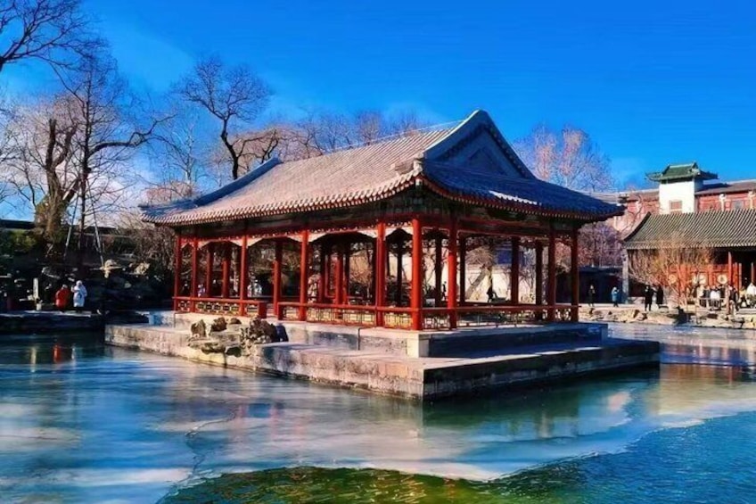 Ein traditionelles Pavillon an einem ruhigen Gewässer, umgeben von Bäumen und anderen Gebäuden. 5