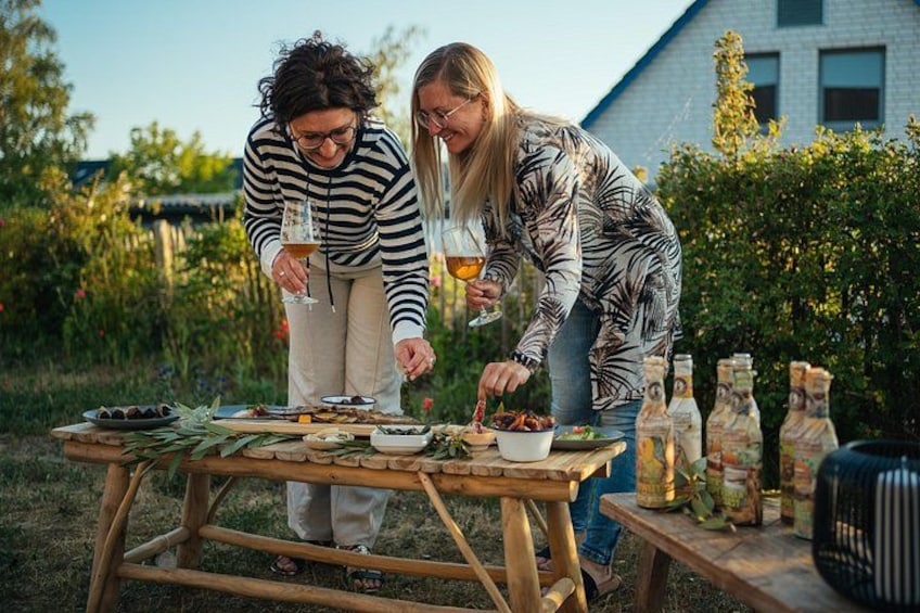 Dos personas en un picnic al aire libre, con comida y bebidas sobre una mesa de madera. 5