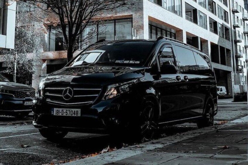 A black Mercedes-Benz SUV parked on a city street. 1