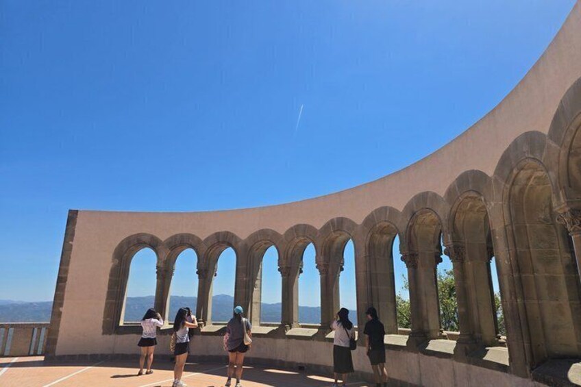 A curved architectural structure with multiple arches and a clear blue sky. 3