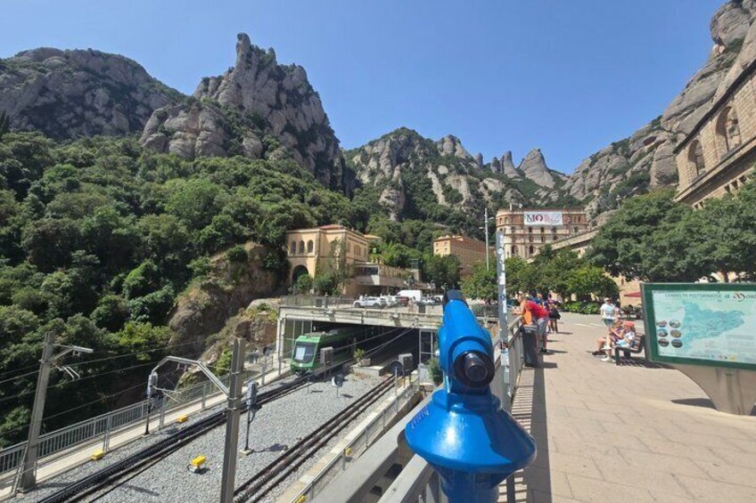 A mountainous landscape with a bridge, a blue structure, and a signboard. 5