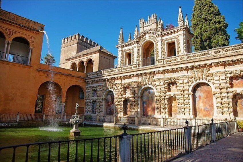 Un edificio histórico con arquitectura ornamentada, una fuente y un patio bien cuidado. 4