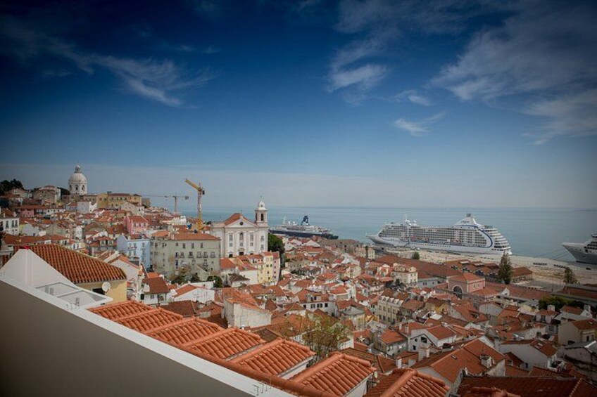 A coastal cityscape with historic buildings, a cruise ship, and a construction crane. 4