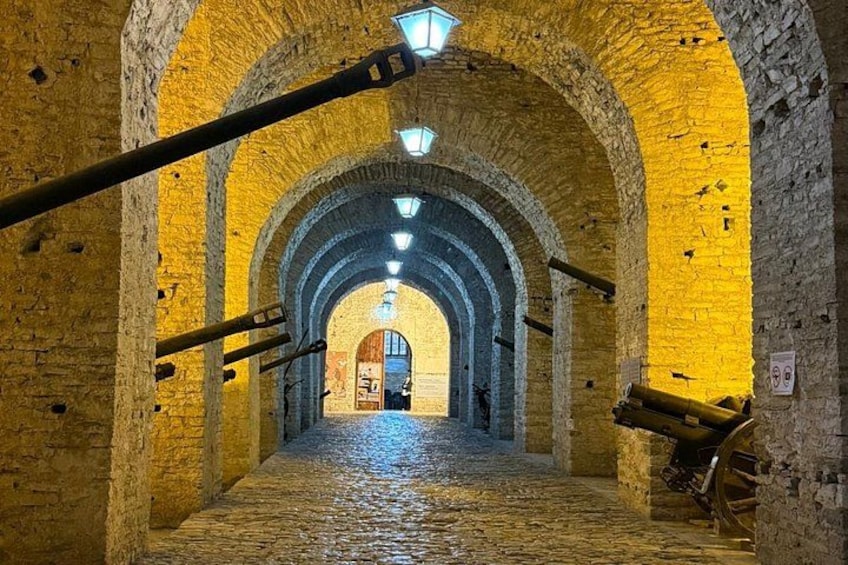 En stengang med hvælvede lofter og brostensbelagt gulv. 5