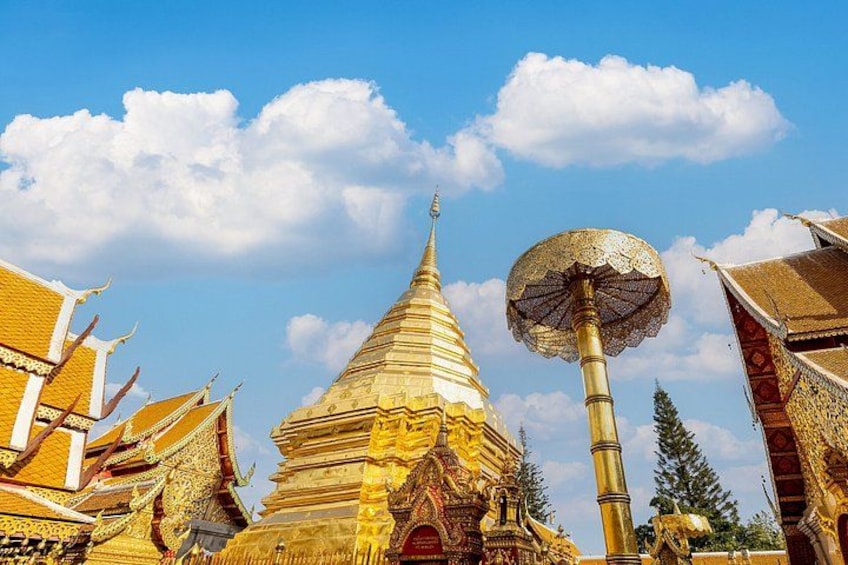 Une pagode dorée aux motifs complexes, une grande structure en forme de parasol et une architecture thaïlandaise traditionnelle. 5