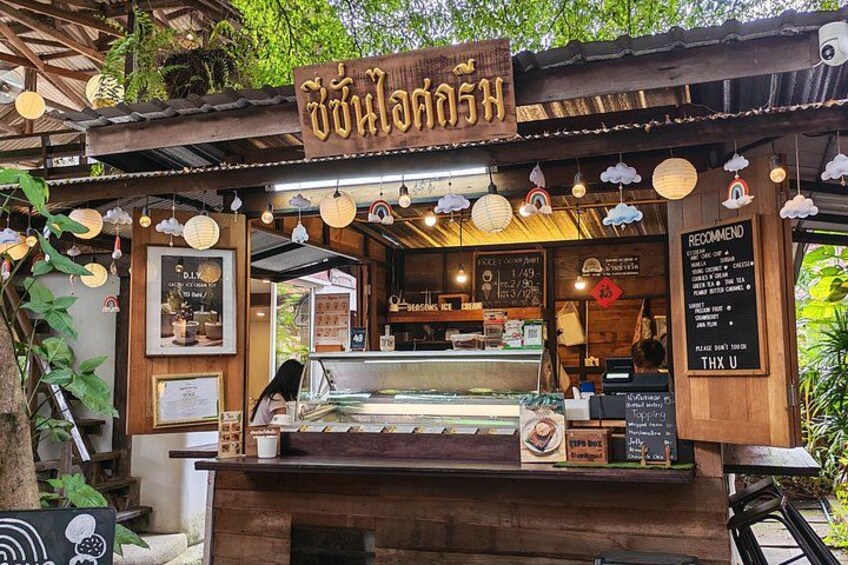 Un stand de nourriture avec une enseigne en bois, des guirlandes lumineuses et un panneau affichant le menu. 2
