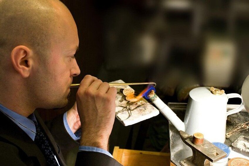 A person eating with chopsticks, a white mug, and a plate with food. 1