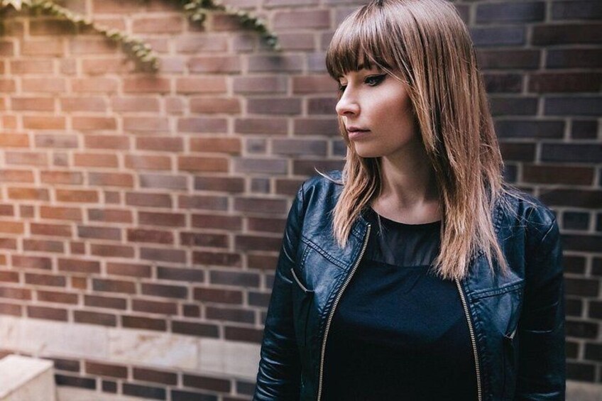A person standing in front of a brick wall. 5