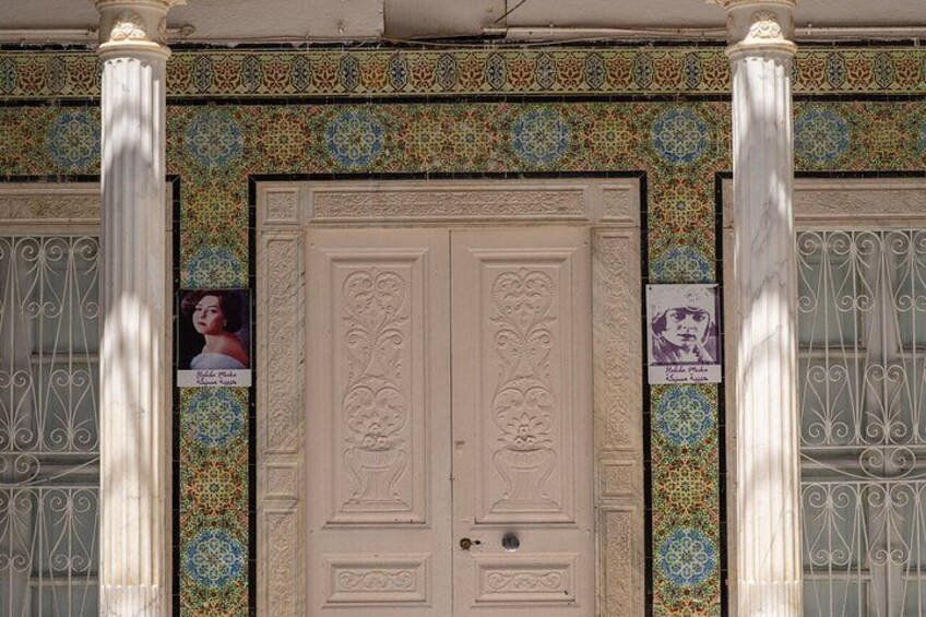 Fachada de edificio con puertas ornamentadas, azulejos decorativos y celosías de metal. 2