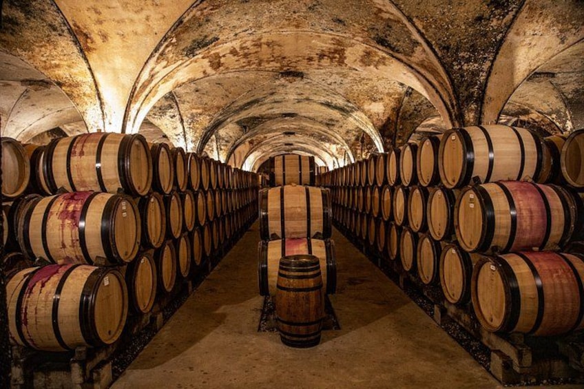 A wine cellar with rows of wooden barrels. 2