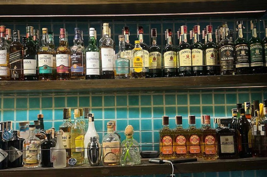 Eine Bar mit Regalen voller verschiedener Spirituosenflaschen. 4