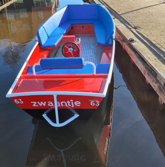 A red and blue narrowboat docked at a canal. 4