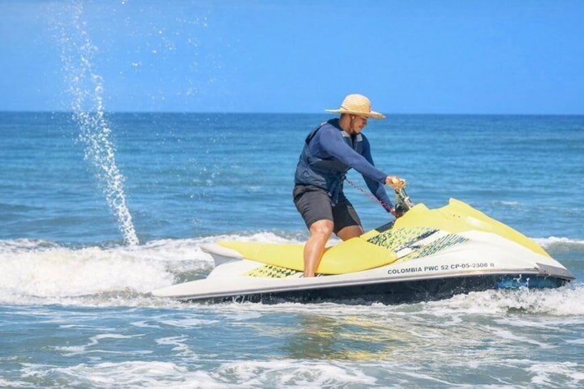 Eine Person fährt mit einem gelb-weißen Jetski, auf dem 'COLOMBIA PWC 52 CP-05-2308' steht. 5