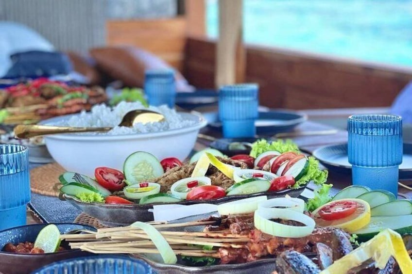 Ett bord med olika rätter, inklusive grillat kött, grönsaker och ris. 2