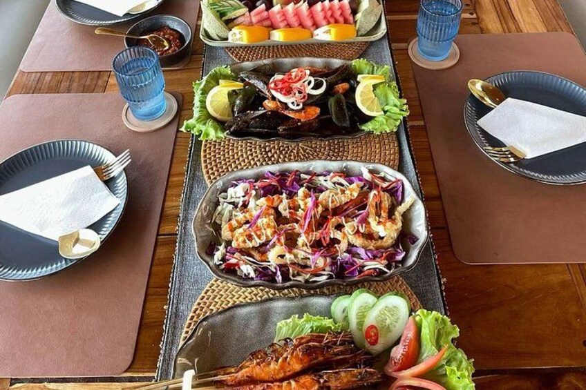 A table with various dishes, including seafood, salads, and vegetables, arranged for a meal. 2