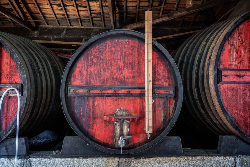 Three large wooden barrels with metal hoops, stacked in a row. 4