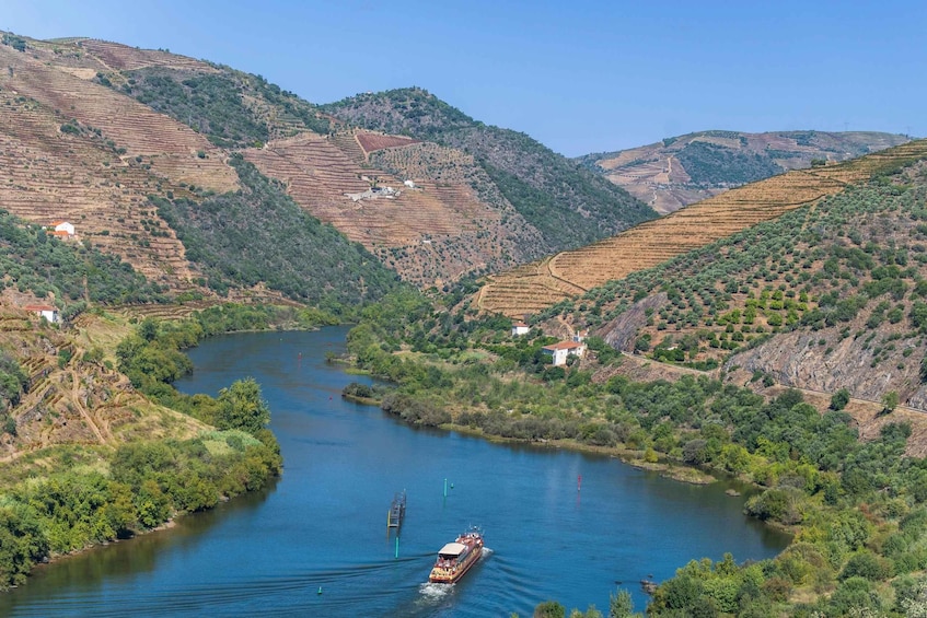 A river winding through terraced hills with a boat in the water. 1