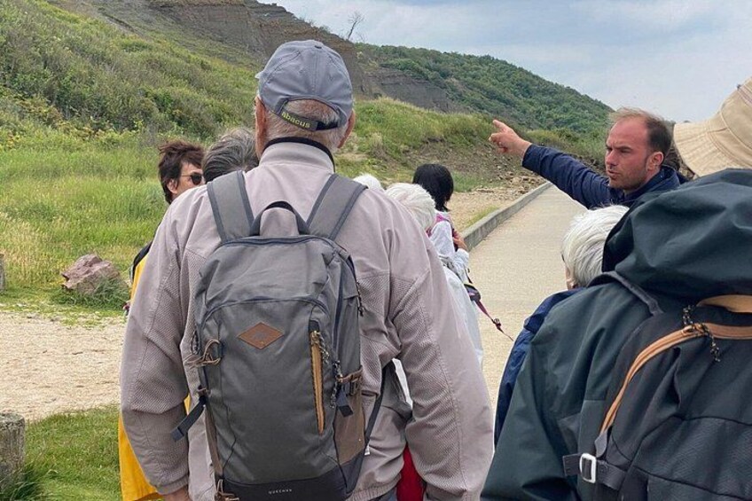 A group of people hiking on a trail with a hiker pointing towards the path. 2