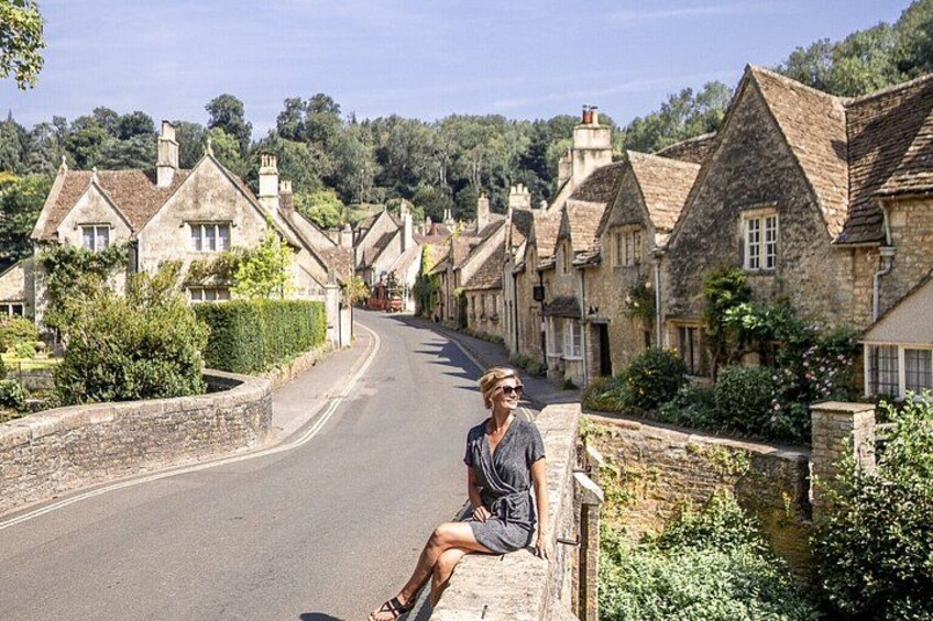 A person sitting on a stone wall in a village with stone houses and a road. 3