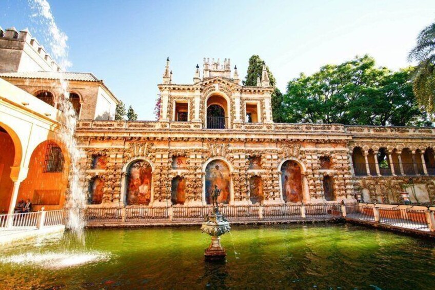 Un edificio storico con elaborati decori in pietra e una fontana nel cortile. 1