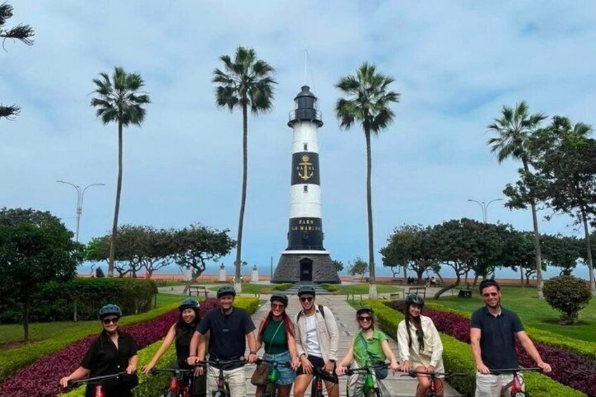 Eine Gruppe von Radfahrern vor einem Leuchtturm. 3