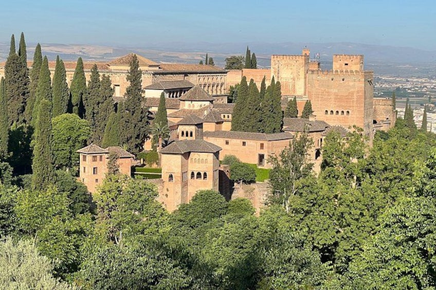 Une forteresse historique, dotée de tours et de remparts, entourée de verdure et d’arbres. 2