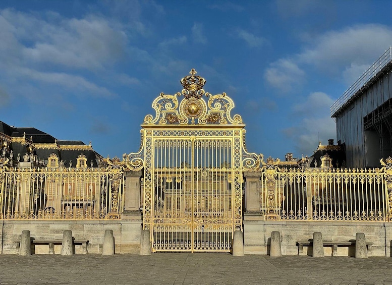 A grand, ornate gate with intricate gold detailing and a prominent crown atop. 4