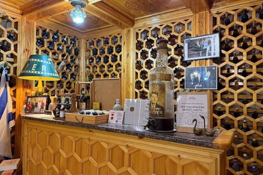 A bar with wooden paneling, a green lamp, and a bottle of liquor. 2