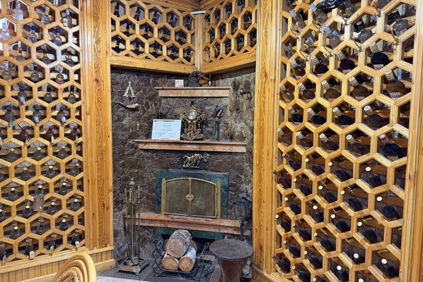 A wine cellar with wooden racks and a stone fireplace. 4