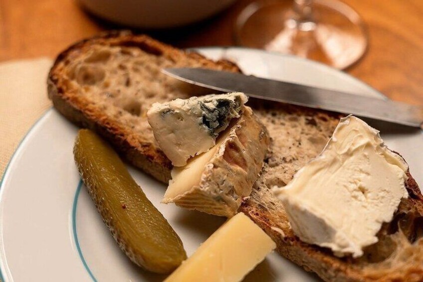 Une assiette avec des tranches de pain, un morceau de fromage et un cornichon. 5