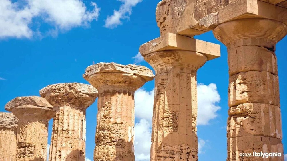 Ancient stone columns with capitals against a clear blue sky. 2