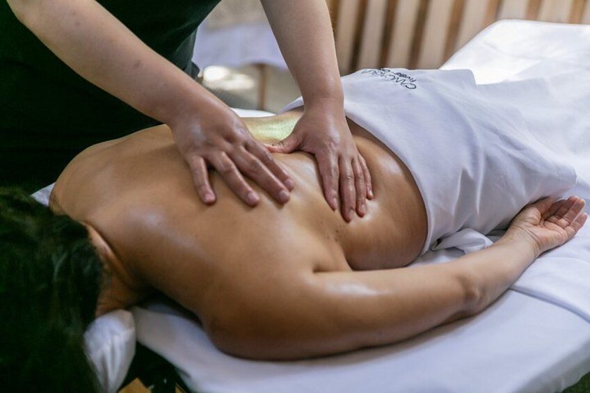 A person receiving a back massage on a massage table. 5