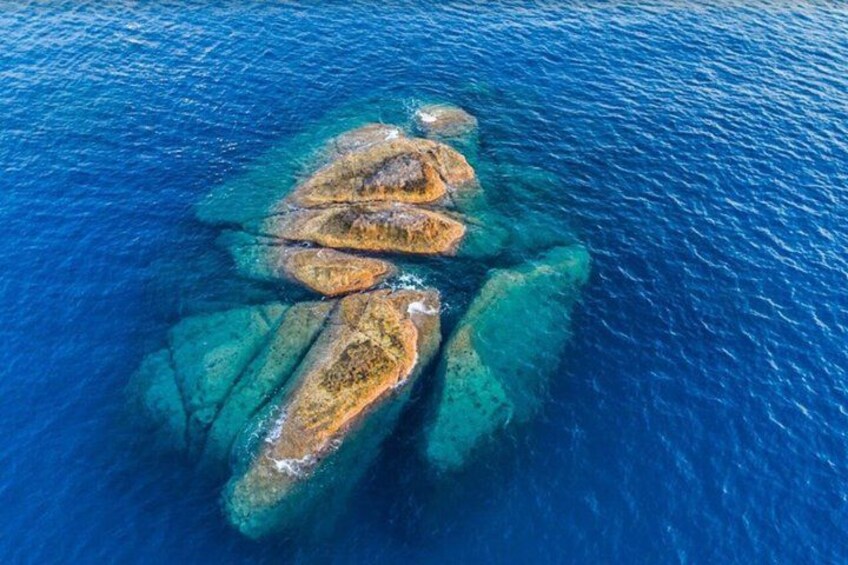 An aerial view of a coral reef with clear blue water and visible coral formations. 3
