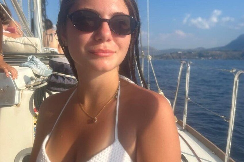 A person on a boat with a clear view of the sea and distant land. 3