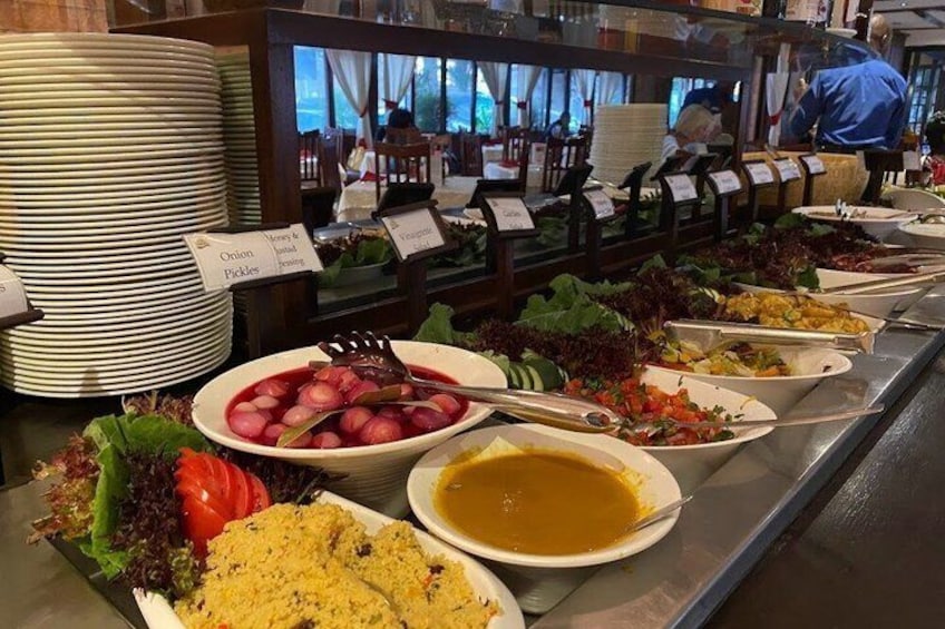 Un bufé con diversos platos, como ensaladas, escabeche y un bol de sopa. 4
