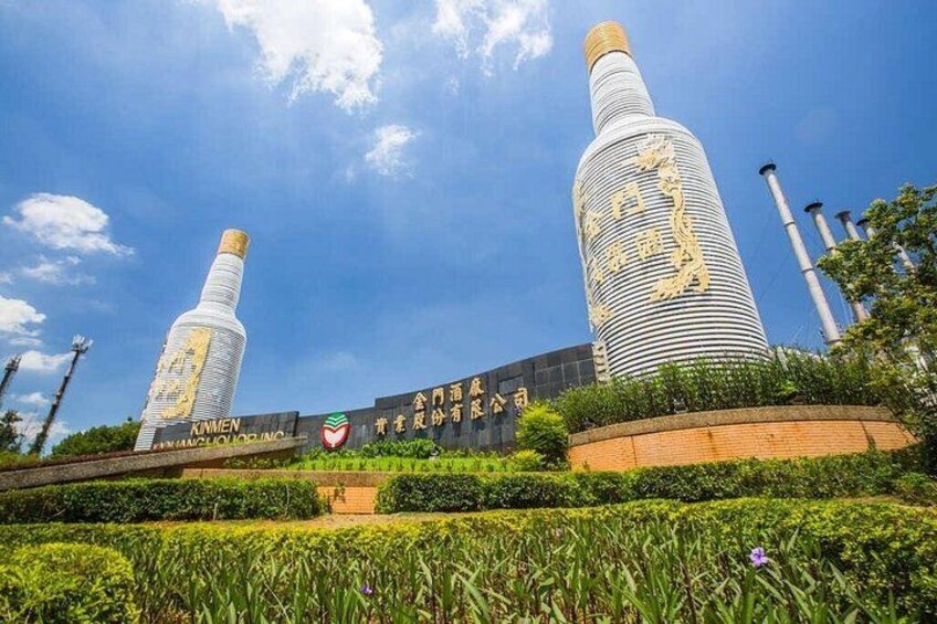 A building with two tall structures resembling bottles, surrounded by greenery and a clear sky. 5
