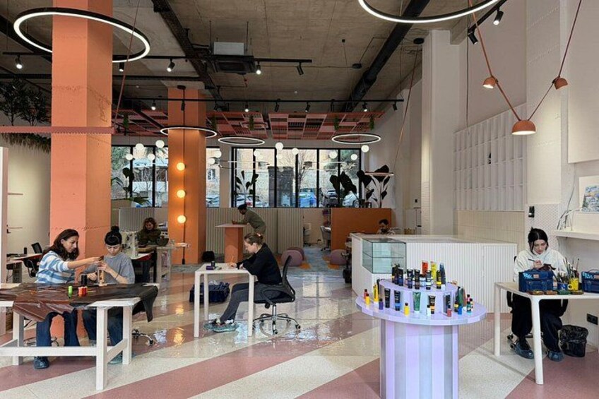 Un interior moderno con mesas y sillas, un mostrador con productos y ventanas amplias. 3