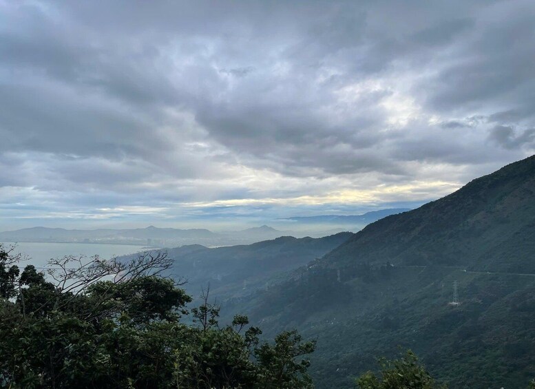 A mountainous landscape with a valley and a body of water in the distance. 3