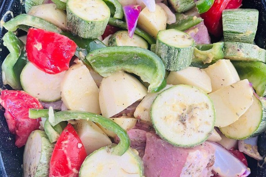 Sliced zucchini, tomatoes, and onions in a pan. 3