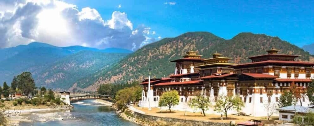 A traditional building with multiple tiers and red roofs, surrounded by a river and mountains. 3