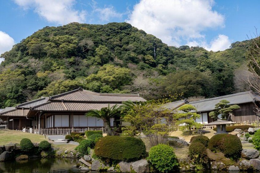 Traditional Japanese buildings, a pond, and a mountainous backdrop. 3