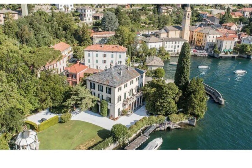 An aerial view of a riverside town with historic buildings, a prominent tower, and a bridge. 5