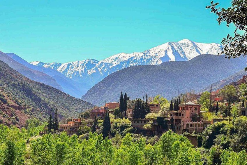 A village nestled in a valley with snow-capped mountains in the background. 2