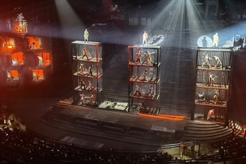 Eine Bühne mit zwei großen Metallkonstruktionen, jeweils mit Figuren obenauf und Regalen darunter. 3