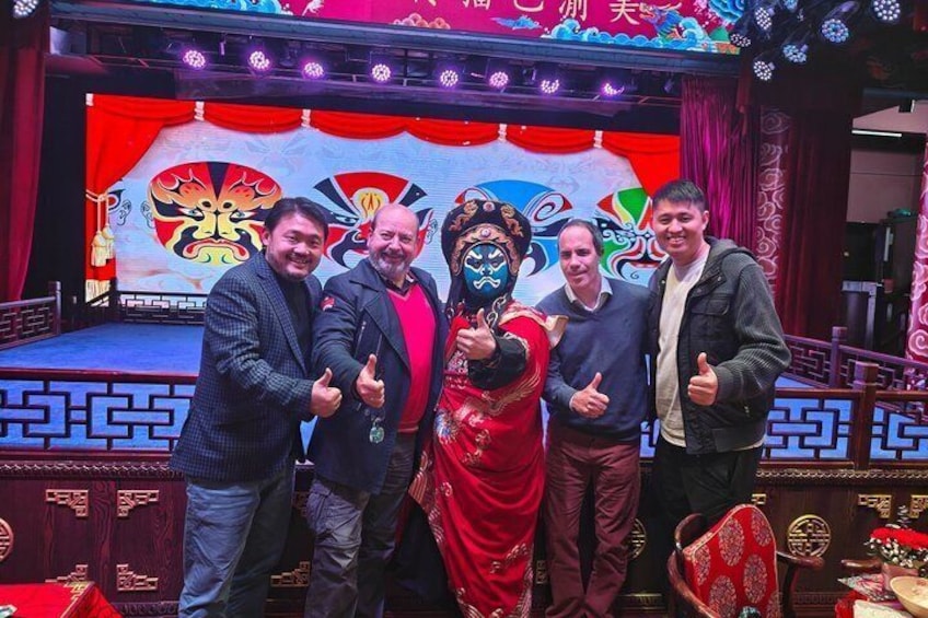 Eine Gruppe von Menschen auf einer Bühne vor einem traditionellen chinesischen Hintergrund. 1