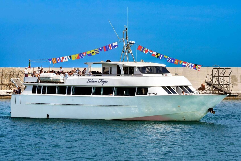 A white boat named 'Colian Flyer' with the number 'MZ 1704' on the side, sailing on clear blue water. 4