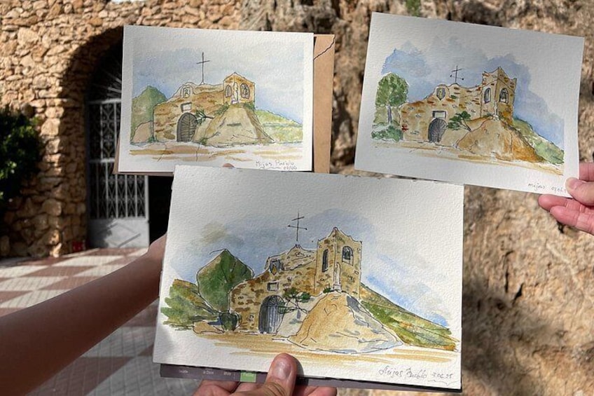 A person holding two watercolor paintings of a church on a hill. 4