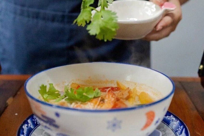 Un cuenco de comida con un borde azul y un plato decorativo debajo. 3