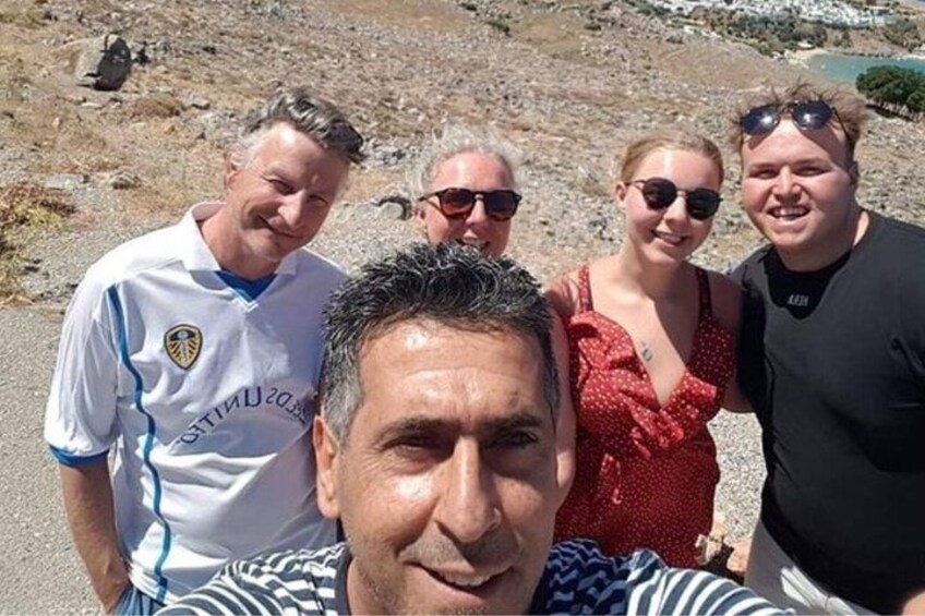 A group of people on a rocky beach with a clear sky. 2
